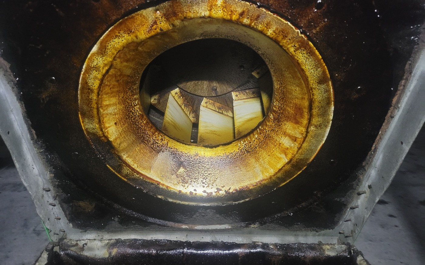 Grease-covered exhaust fan housing before cleaning